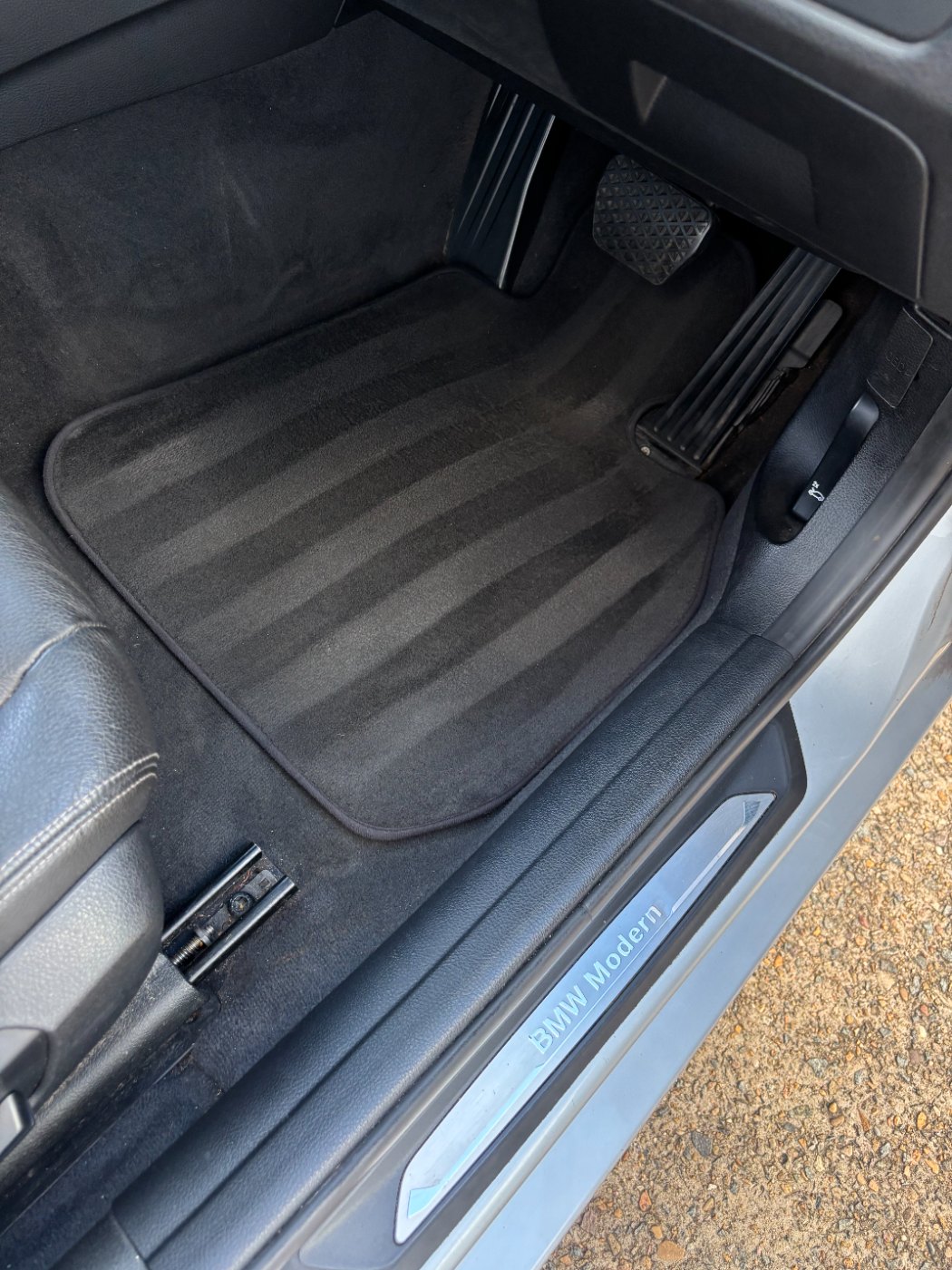 BMW driver footwell after detailing — mat and carpet cleaned